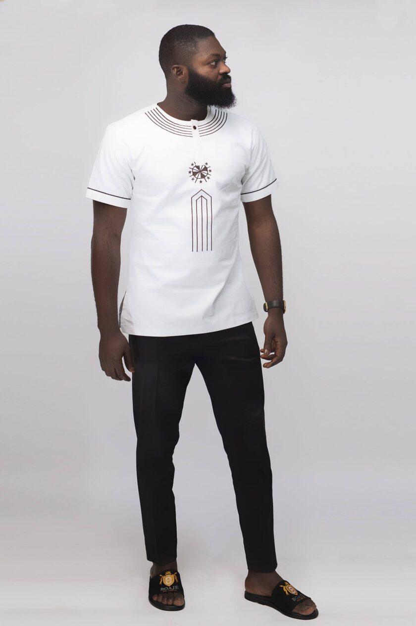 Frontal of model wearing our Mikaili Slim Fit Embroidered African Shirt in pure white with simple brown embroidery detail on neckline, chest and sleeves.