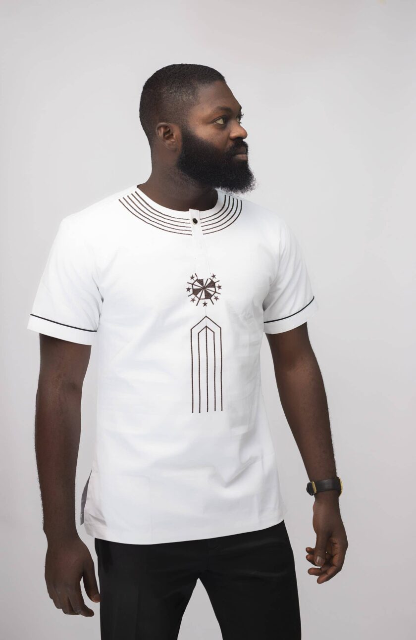 Close shot of model wearing our Mikaili Slim Fit Embroidered African Shirt in pure white with simple brown embroidery detail on neckline, chest and sleeves.