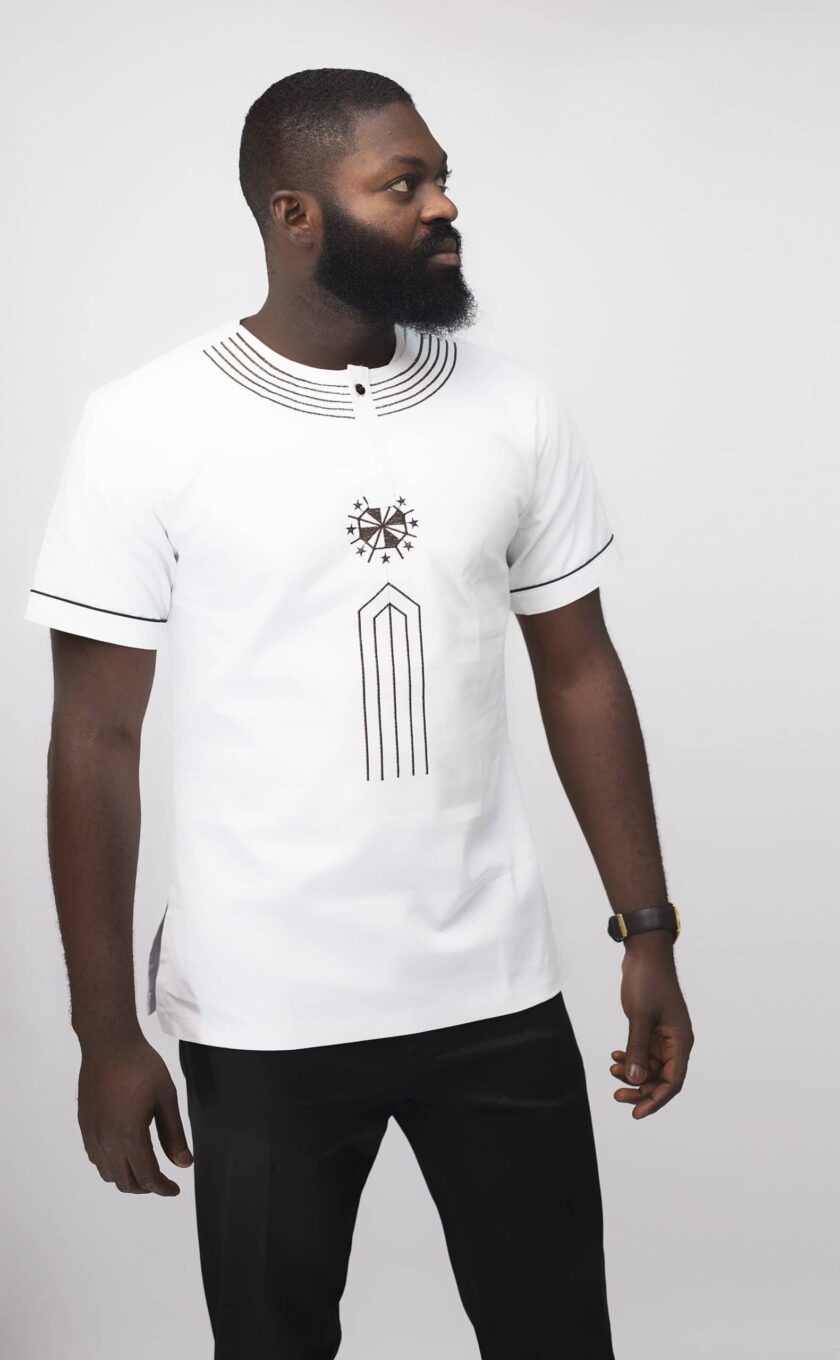 Frontal of model wearing our Mikaili Slim Fit Embroidered African Shirt in pure white with simple brown embroidery detail on neckline, chest and sleeves.
