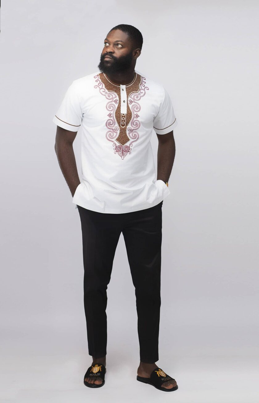 Frontal of model wearing our Malomo Slim Fit Embroidered African Shirt in pure white with elaborate maroon red embroidery and contrasting brown embellishment on the neckline.