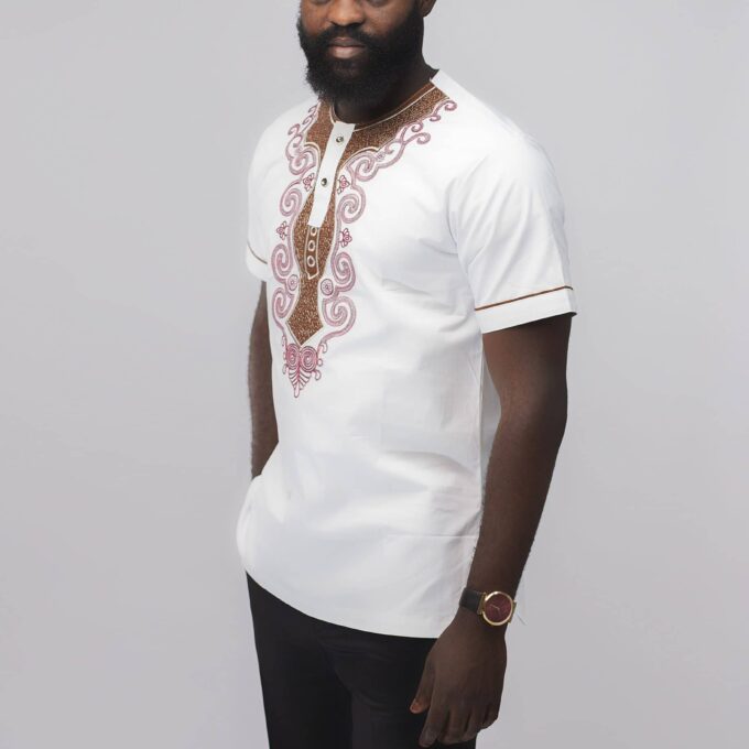 Side shot of model wearing our Malomo Slim Fit Embroidered African Shirt in pure white with elaborate maroon red embroidery and contrasting brown embellishment on the neckline.