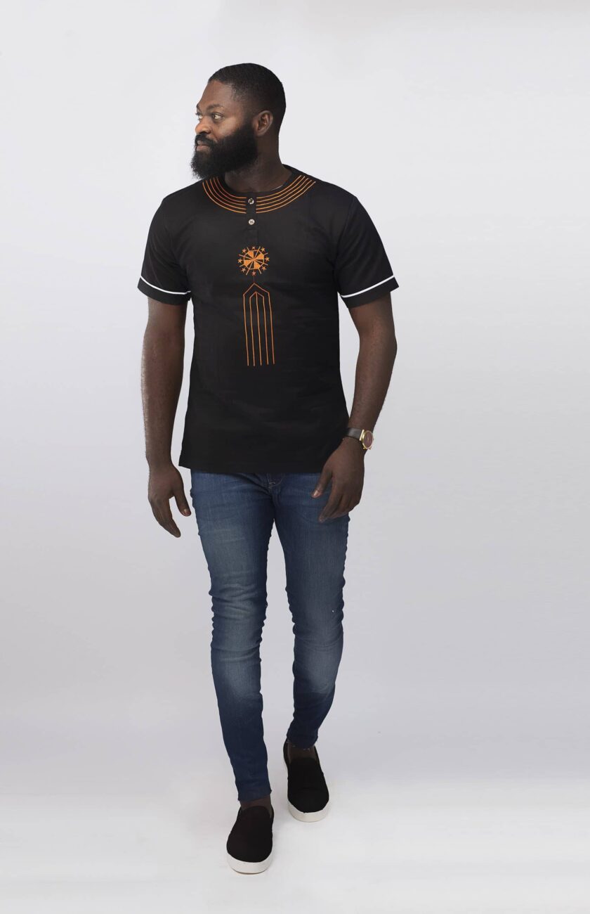 Full frontal of model wearing our Mahbubi slim fit short sleeved black shirt with orange embroidery on the chest and neckline.