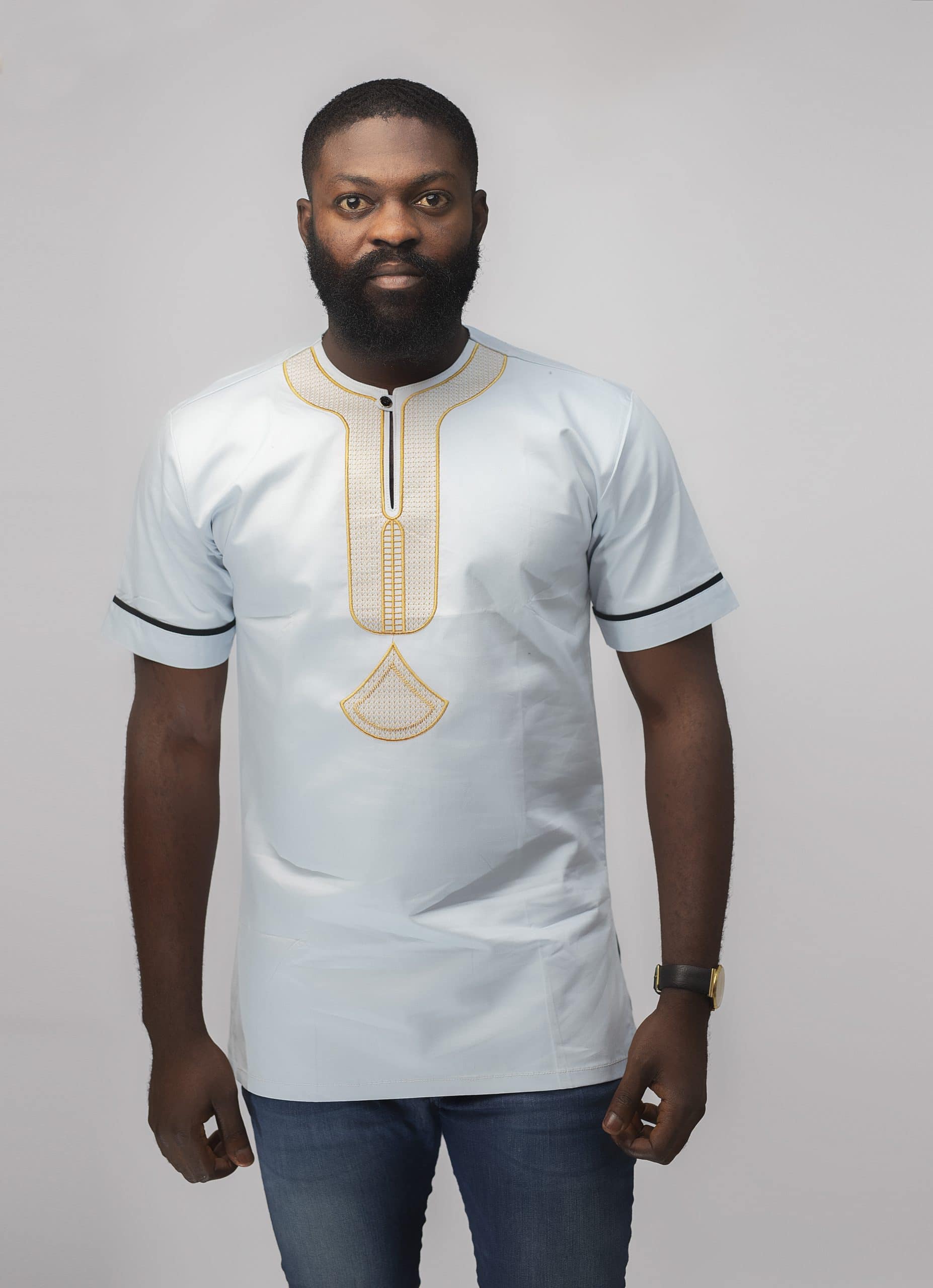 Frontal of model wearing our Mamello Slim Fit Embroidered African Shirt in off-white or pale blue with abstract gold embroidery.