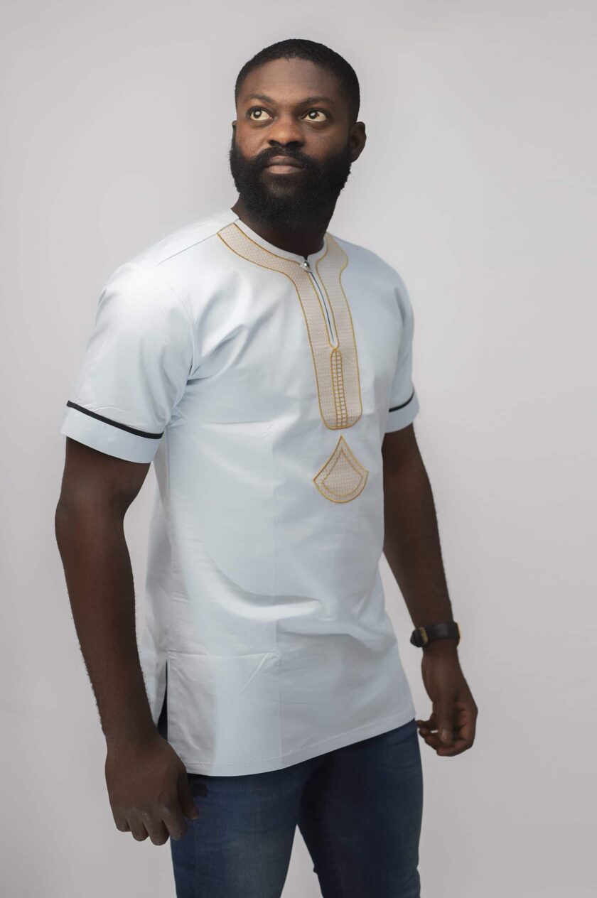 Side shot of model wearing our Mamello Slim Fit Embroidered African Shirt in off-white or pale blue with abstract gold embroidery.