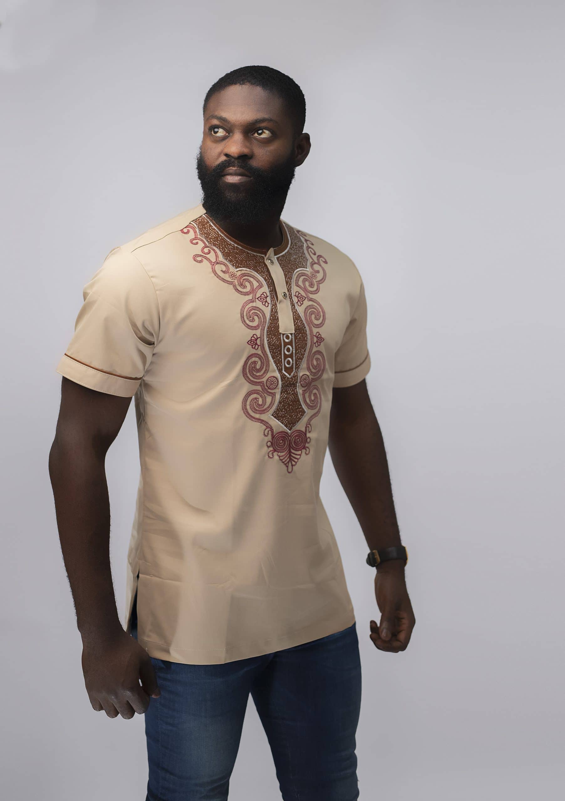 Side shot of model wearing our Melange Slim Fit Embroidered African Shirt in cream with elaborate red embroidery.