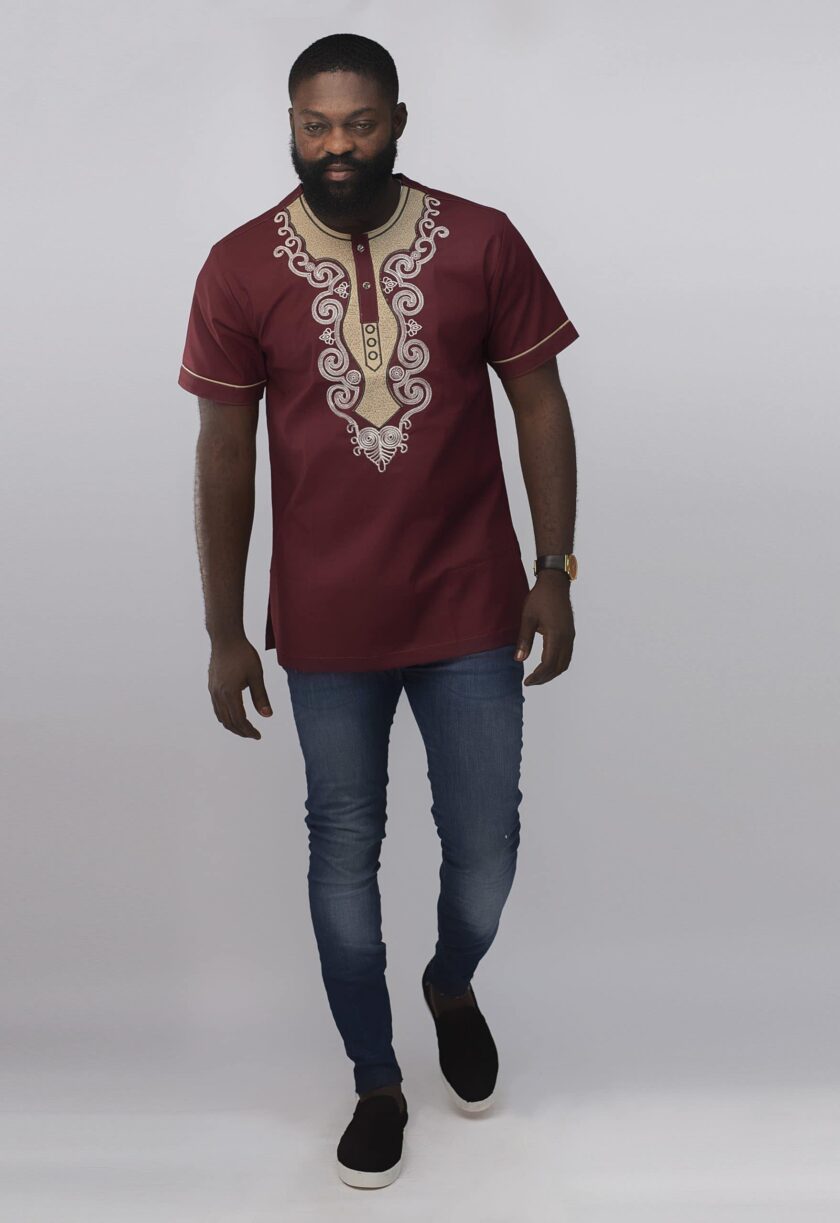 Frontal of model wearing our Muenda Slim Fit Embroidered African Shirt in burgundy / deep red / wine with cream and light pink elaborate embroidery pattern on the neckline, chest and sleeves.