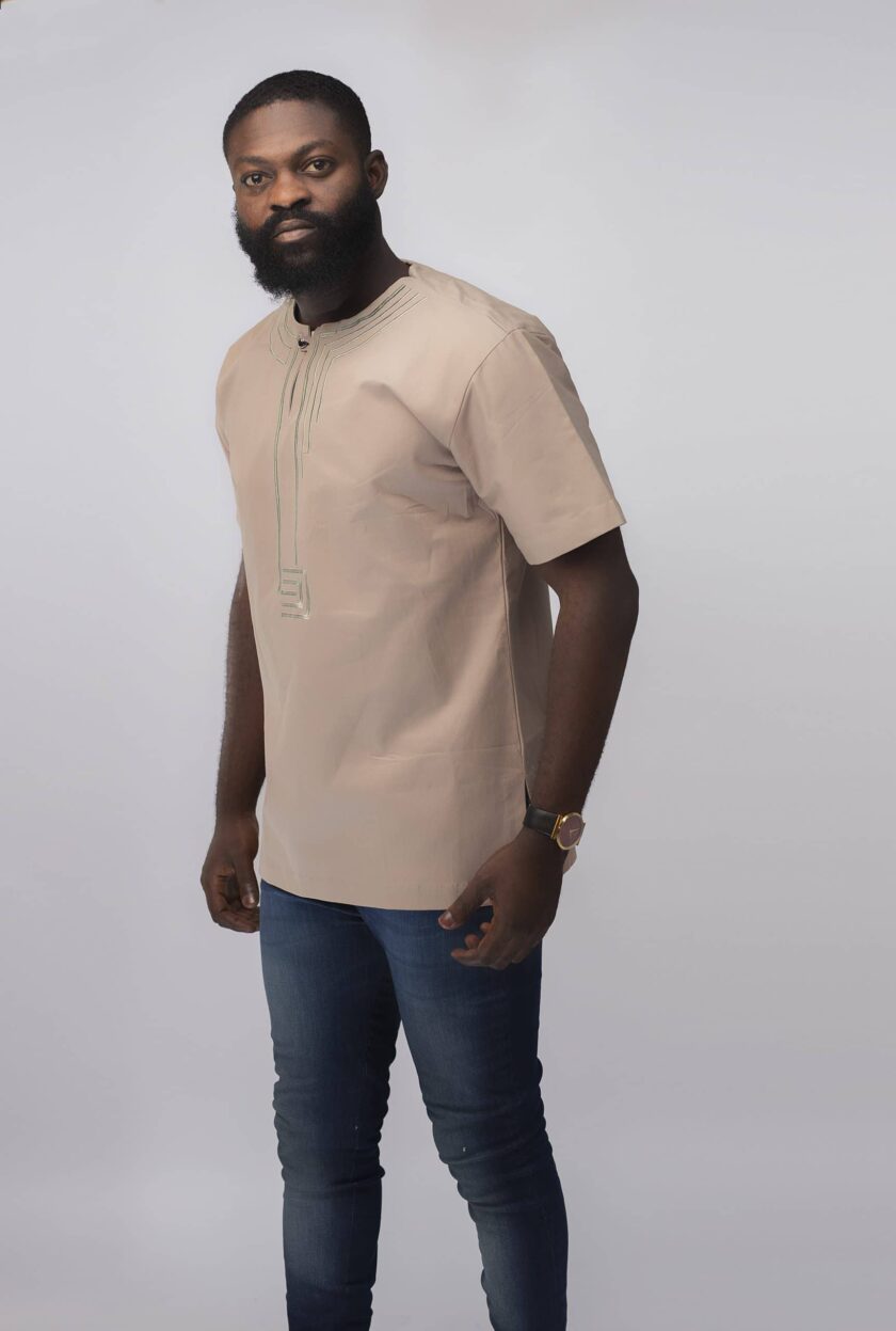 Side shot of model wearing our Modupe Slim Fit Embroidered African Shirt in beige.