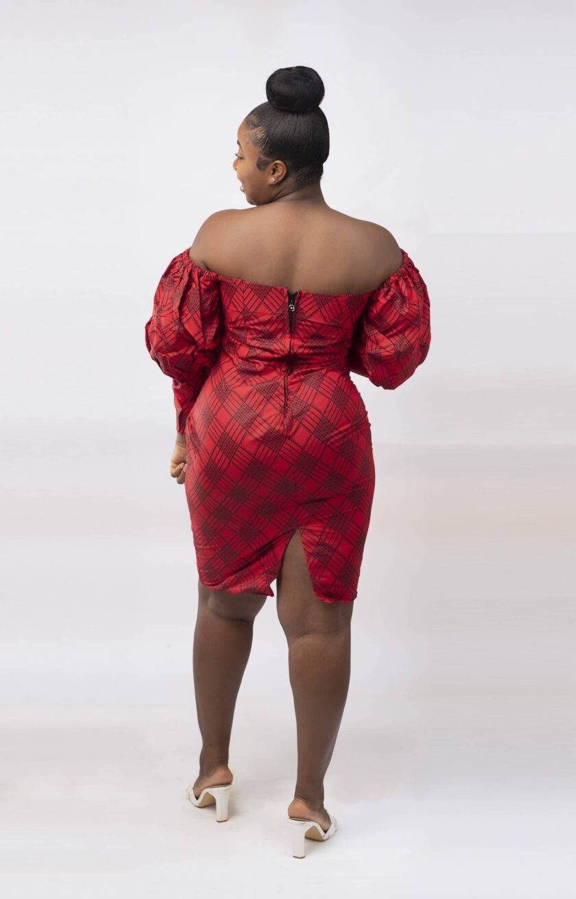 Back shot of model wearing our red and black bodycon off shoulder knee length dress with balloon sleeves and all over African Kente print pattern.