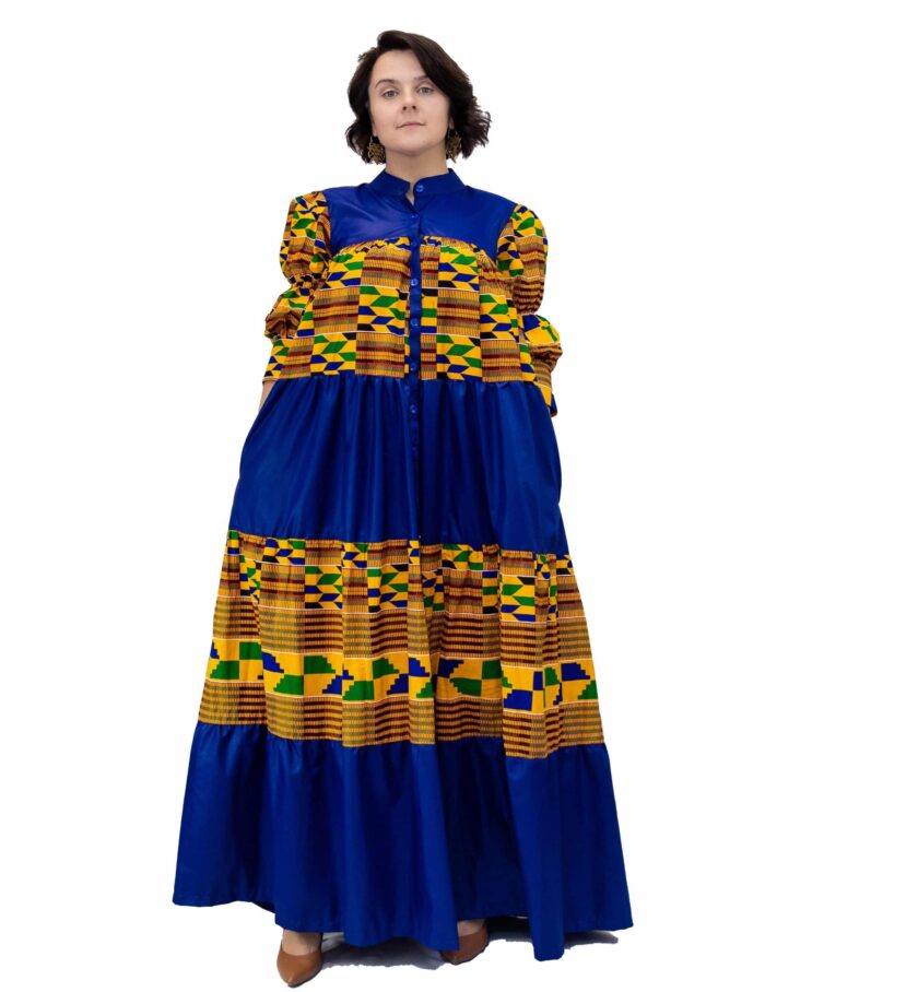 Frontal of model wearing a blue and multi-coloured African Kente print smock maxi dress.