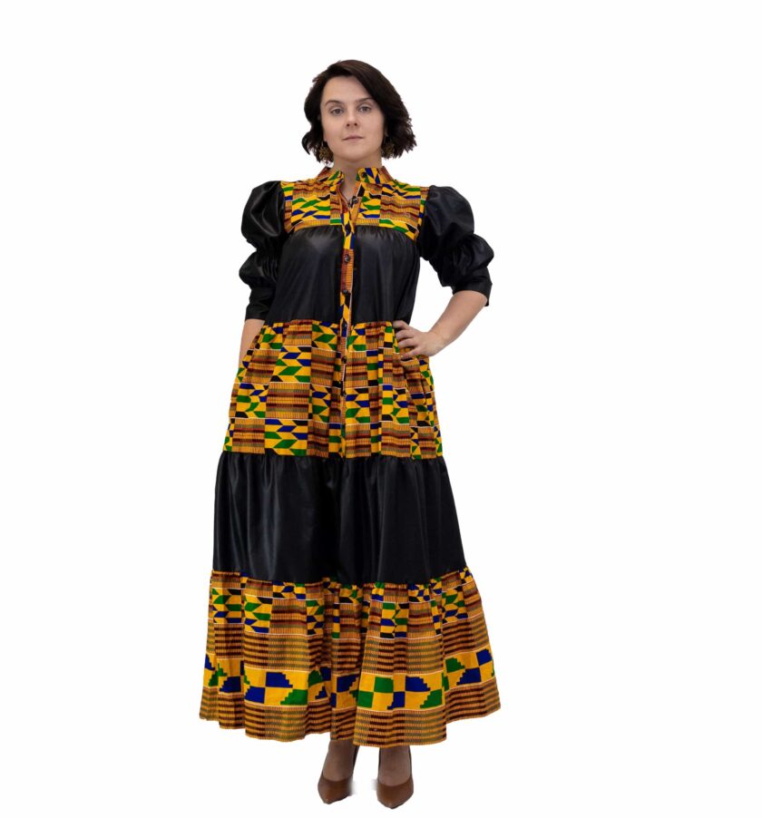 Frontal of model wearing a black and multi-coloured African Kente print smock maxi dress.
