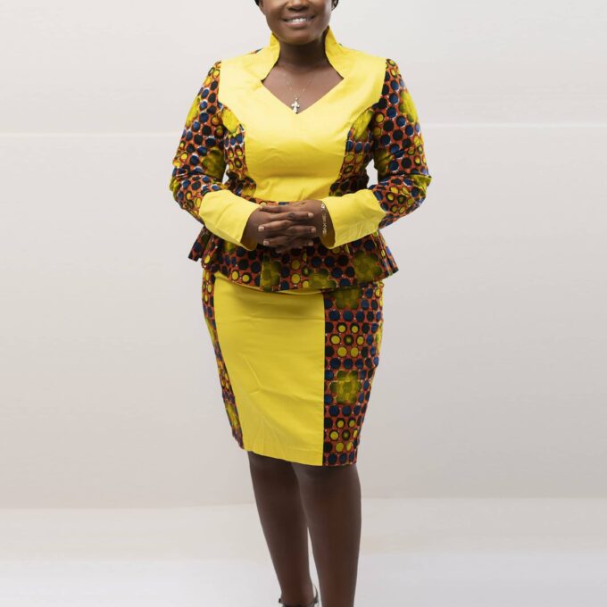 Frontal of model wearing our Zuri two piece matching skirt set in yellow, brown and blue African print. Features a statement collar and contrasting solid yellow panel on front and cuffs.