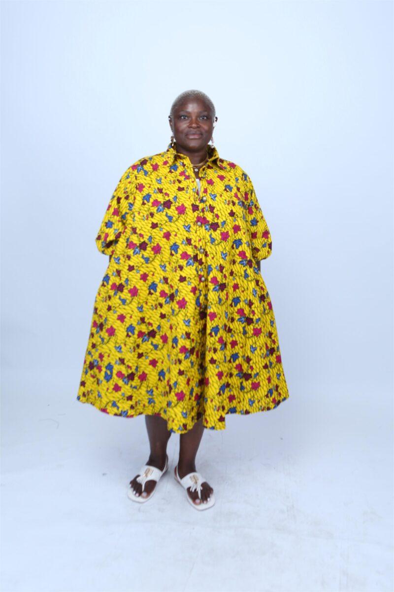 Model wearing a yellow African print dress