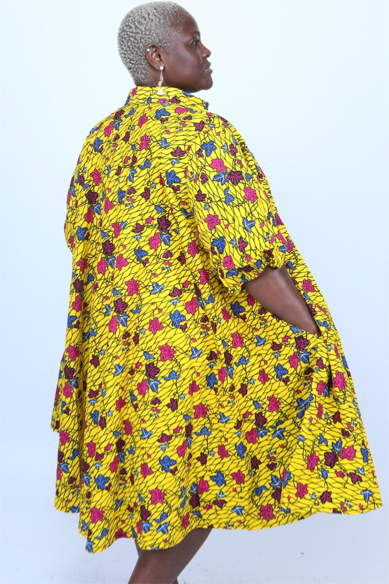 Model wearing a yellow African print dress