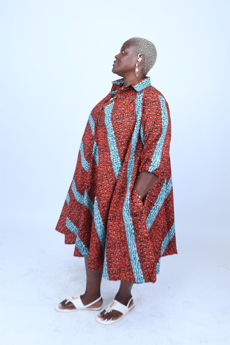 Woman wearing and orange and red striped African print shirt dress