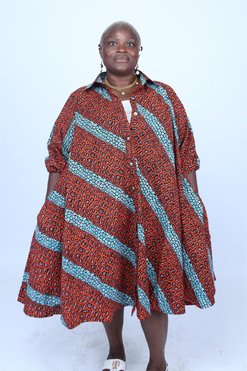 Woman wearing and orange and red striped African print shirt dress