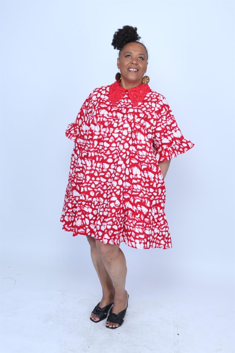 Woman posing while wearing a red and white african dress