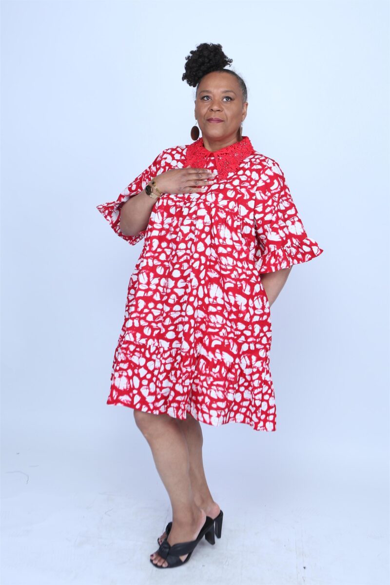 Woman posing while wearing a red and white african dress